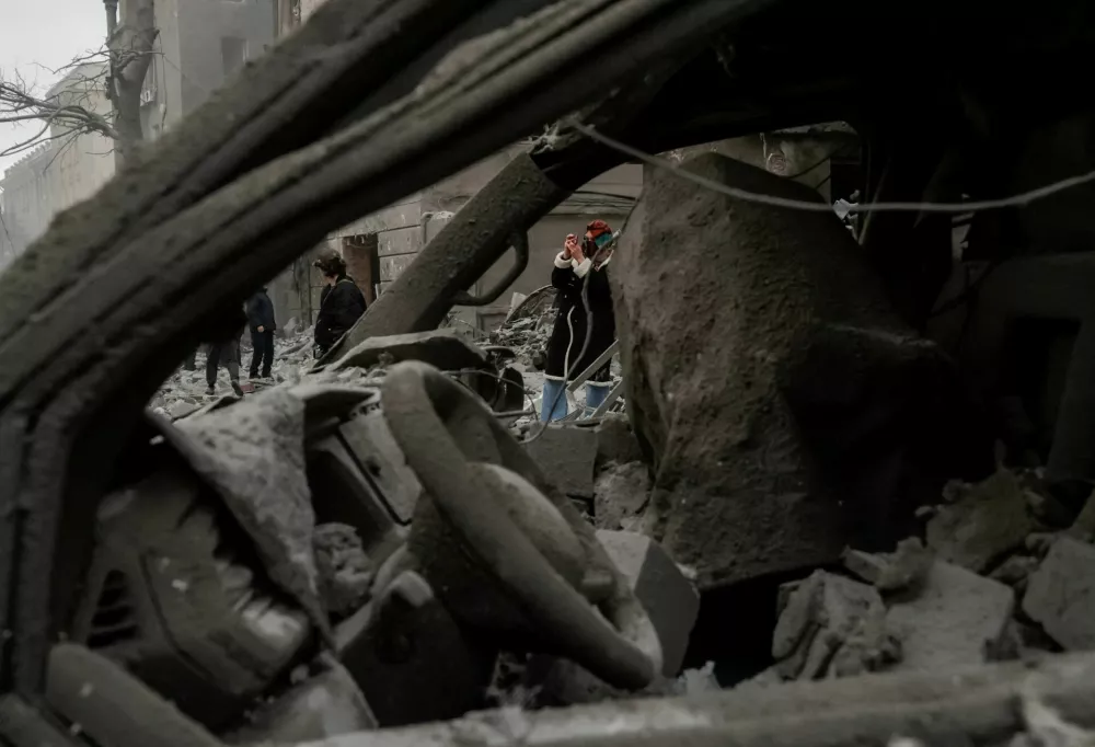 A resident takes a picture at the site of an apartment building hit by a Russian air strike, amid Russia's attack on Ukraine, in Kharkiv, Ukraine January 2, 2026. REUTERS/Sofia Gatilova   TPX IMAGES OF THE DAY