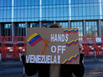 A man from the Communist Party of Britain (CPB) group holds a banner outside the U.S. Embassy in London calling for "Hands off Venezuela!" after U.S. President Donald Trump said the U.S. has struck Venezuela and captured its President Nicolas Maduro and his wife Cilia Flores, in London, Britain, January 3, 2026. REUTERS/Carlos Jasso