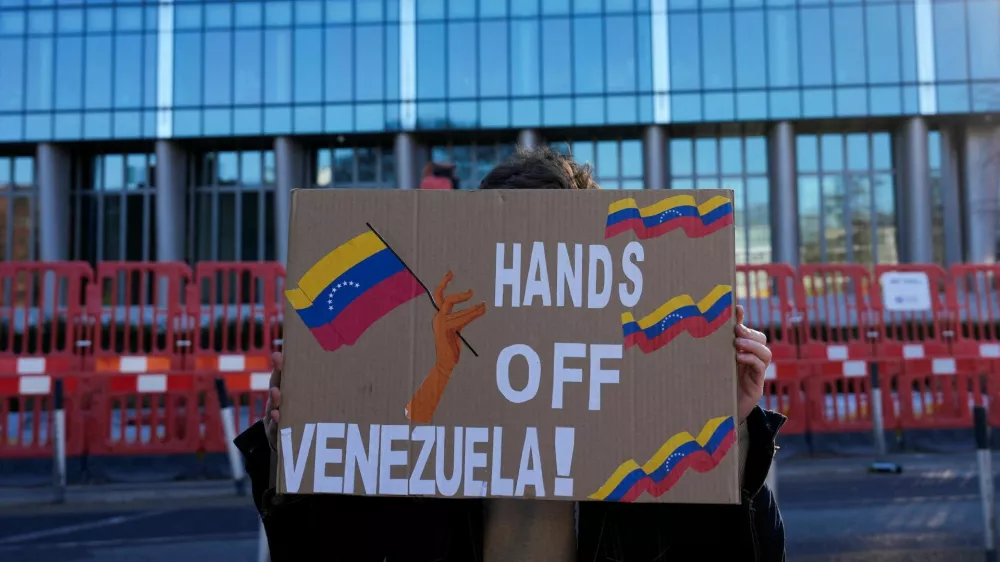 A man from the Communist Party of Britain (CPB) group holds a banner outside the U.S. Embassy in London calling for "Hands off Venezuela!" after U.S. President Donald Trump said the U.S. has struck Venezuela and captured its President Nicolas Maduro and his wife Cilia Flores, in London, Britain, January 3, 2026. REUTERS/Carlos Jasso