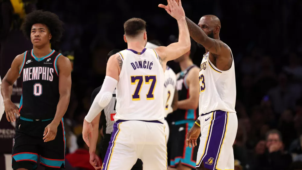 Jan 4, 2026; Los Angeles, California, USA; Los Angeles Lakers forward LeBron James (right) is greeted by forward Luka Doncic (77) after making a basket during the fourth quarter against the Memphis Grizzlies at Crypto.com Arena. Mandatory Credit: Kiyoshi Mio-Imagn Images
