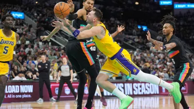 Jan 7, 2026; San Antonio, Texas, USA; Los Angeles Lakers forward/guard Luka Dončić (77) draws a foul in between San Antonio Spurs forward/center Victor Wembanyama (1) and guard Stephon Castle (5) in the second half at Frost Bank Center. Mandatory Credit: Daniel Dunn-Imagn Images