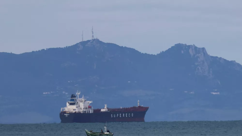 A Moroccan fisherman sails next to an oil tanker crossing the Strait of Gibraltar with the Atlas Mountains in the background, near the Spanish town of Tarifa, as seen from Tangier, Morocco, January 8, 2026. REUTERS/Amr Abdallah Dalsh