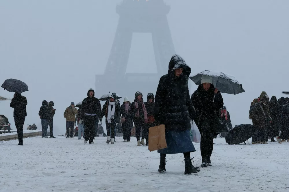 People walk in the snow-covered Trocadero square near the Eiffel Tower, as winter weather with snow and cold temperatures hits a large part of the country, in Paris, France, January 5, 2026. REUTERS/Gonzalo Fuentes   TPX IMAGES OF THE DAY / Foto: Gonzalo Fuentes