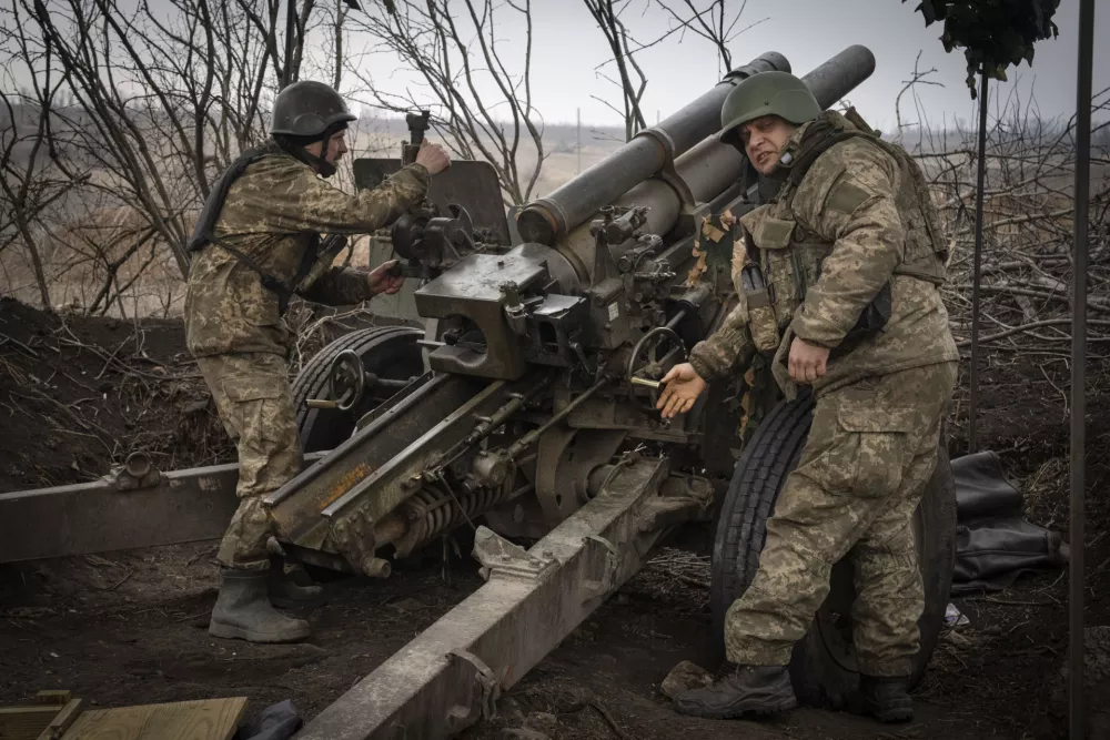 FILE - Ukrainian soldiers of the 71st Jaeger Brigade fire a M101 howitzer towards Russian positions at the frontline, near Avdiivka, Donetsk region, Ukraine, Friday, March 22, 2024. Much of what NATO can do for Ukraine, and indeed for global security, is misunderstood. Often in the public mind, the alliance is thought of as the sum of all U.S. relations with its European partners, from imposing sanctions and other costs on Russia to sending arms and ammunition. But as an organization its brief is limited to the defense by military means of its 32 member countries and a commitment to help keep the peace in Europe and North America. (AP Photo/Efrem Lukatsky, File)