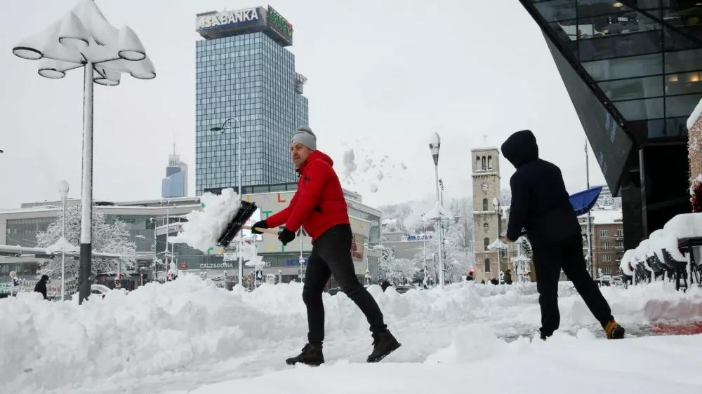 People clear snow from a street in Sarajevo, Bosnia and Herzegovina, January 5, 2026. REUTERS/Amel Emric