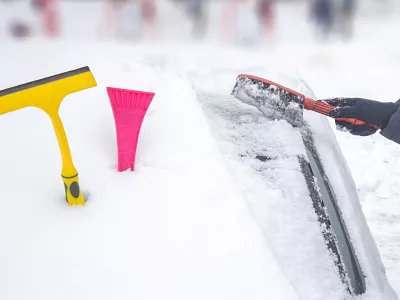 Clearing the snow from the car in the winter in the yard with a shovel, brush and scraper / Foto: Ruslan Khismatov, Getty Images/istockphoto