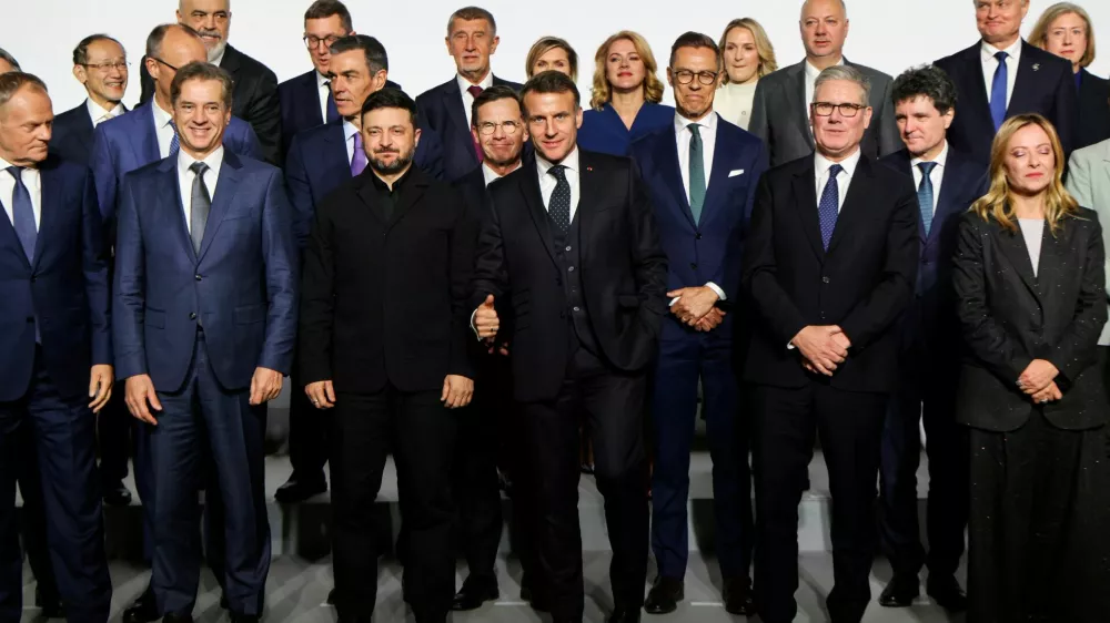 France's President Emmanuel Macron gestures as Poland's Prime Minister Donald Tusk, Slovenia's Prime Minister Robert Golob, Ukraine's President Volodymyr Zelenskiy, Britain's Prime Minister Keir Starmer and Italy's Prime Minister Giorgia Meloni react as they arrive to pose for a family photo on the sideline of the so-called 'Coalition of the Willing' summit, at the Elysee Palace in Paris, France, January 6, 2026. LUDOVIC MARIN/Pool via REUTERS