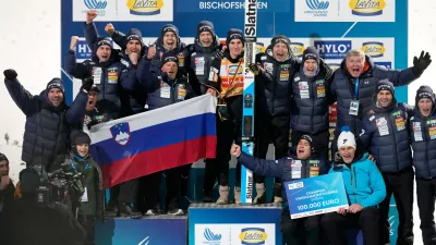 Domen Prevc, of Slovenia, center, poses with his team after winning the Four Hills ski jumping tournament in Bischofshofen, Austria, Tuesday, Jan. 6, 2026. (AP Photo/Matthias Schrader)