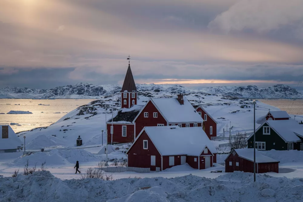 FILE - A woman walks near a church in Nuuk, Greenland, on March 7, 2025. (AP Photo/Evgeniy Maloletka, File)