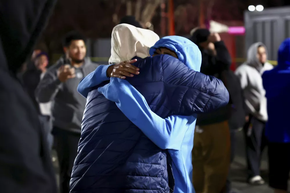 People hug each other after a fatal shooting in a parking lot of The Church of Jesus Christ of Latter-day Saints in Salt Lake City on Wednesday, Jan. 7, 2025. (Laura Seitz/The Deseret News via AP)