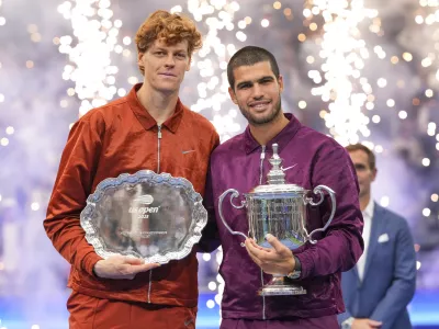 Carlos Alcaraz, of Spain, poses for photos with Jannik Sinner, of Italy, after winning the men's singles final of the U.S. Open tennis championships, Sunday, Sept. 7, 2025, in New York. (AP Photo/Kirsty Wigglesworth)