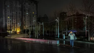 A resident crosses a street during a power blackout after critical civil infrastructure was hit by recent Russian missile and drone attacks, amid Russia's attack on Ukraine, in Dnipro, Ukraine January 8, 2026. REUTERS/Stringer