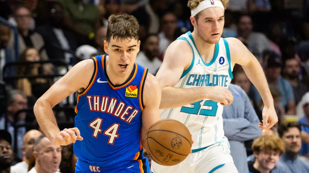 FILE - Oklahoma City Thunder guard Nikola Topic, left, drives the ball upcourt against Charlotte Hornets forward Liam McNeeley, right, during the second half of an NBA basketball preseason game in North Charleston, S.C., Sunday, Oct. 5, 2025. (AP Photo/Mic Smith, File)