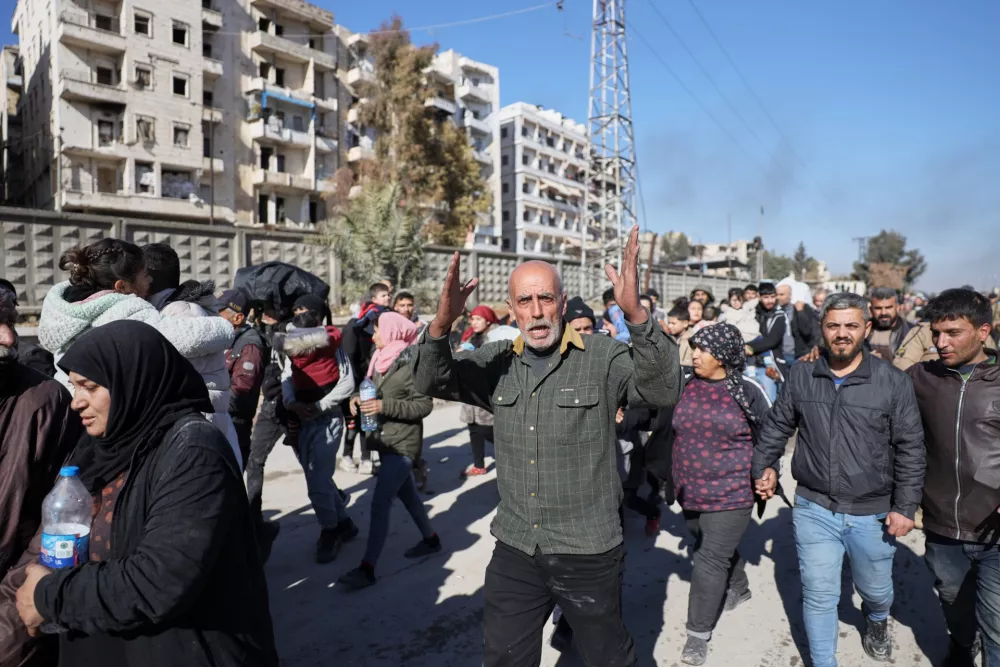 Civilians evacuate an area of the Sheikh Maqsoud neighborhood, where clashes between government forces and Kurdish fighters have been taking place in the northern city of Aleppo, Syria, Saturday, Jan. 10, 2026. (AP Photo/Omar Albam)