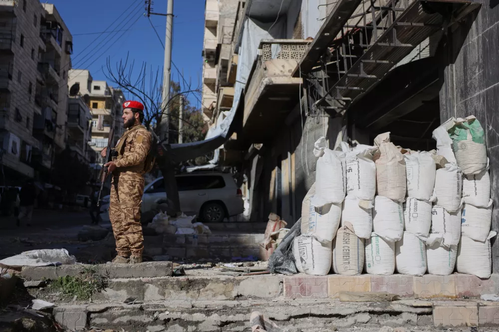 A Syrian military policeman stands guard on a street in the Sheikh Maqsoud neighborhood, where clashes between government forces and Kurdish fighters have been taking place in the northern city of Aleppo, Syria, Saturday, Jan. 10, 2026. (AP Photo/Omar Albam)