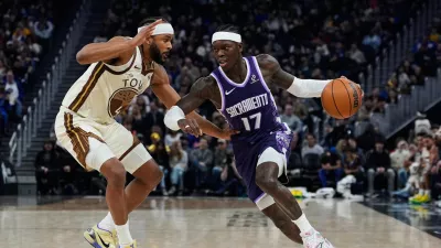 Sacramento Kings guard Dennis Schröder, right, moves the ball while defended by Golden State Warriors guard Moses Moody during the first half of an NBA basketball game, Friday, Jan. 9, 2026, in San Francisco. (AP Photo/Godofredo A. Vásquez)