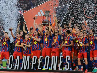 Soccer Football - Spanish Super Cup - Final - FC Barcelona v Real Madrid - King Abdullah Sports City Stadium, Jeddah, Saudi Arabia - January 12, 2026 FC Barcelona's Ronald Araujo lifts the trophy with teammates after winning the Spanish Super Cup final REUTERS/Stringer