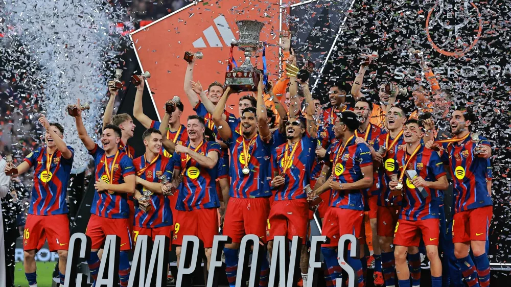 Soccer Football - Spanish Super Cup - Final - FC Barcelona v Real Madrid - King Abdullah Sports City Stadium, Jeddah, Saudi Arabia - January 12, 2026 FC Barcelona's Ronald Araujo lifts the trophy with teammates after winning the Spanish Super Cup final REUTERS/Stringer