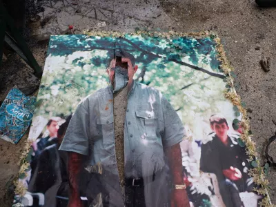 A defaced picture of Abdullah Ocalan, the imprisoned leader of the Kurdistan Workers' Party, or PKK, lies on the floor in the predominantly Kurdish Sheikh Maqsoud neighborhood in the northern city of Aleppo, Syria, Monday, Jan. 12, 2026, where clashes broke out on Jan. 6, between government forces and the Kurdish-led Syrian Democratic Forces. (AP Photo/Omar Albam)