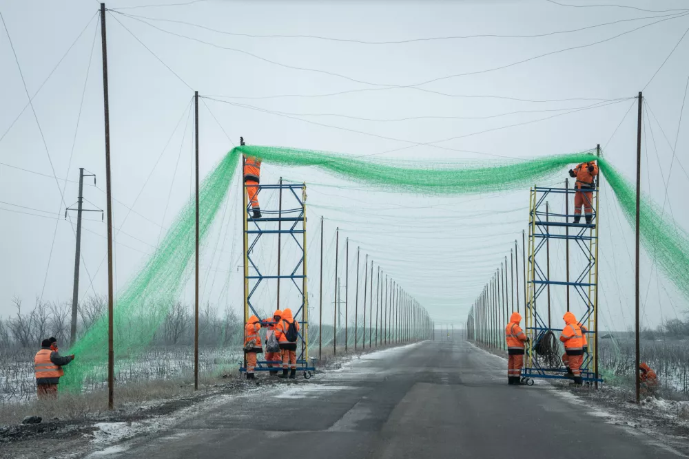 12 January 2026, Ukraine, IziumWorkers are seen installing a protective drone net along the road toward Izium. The frontlines of Ukraine are criss-crossed by anti-drone nets to protect both soldiers and civilians. PhotoTommaso Fumagalli/ZUMA Press Wire/dpa