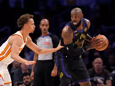 Los Angeles Lakers forward LeBron James, right, tries to get past Atlanta Hawks guard Dyson Daniels during the first half of an NBA basketball game Tuesday, Jan. 13, 2026, in Los Angeles. (AP Photo/Mark J. Terrill)