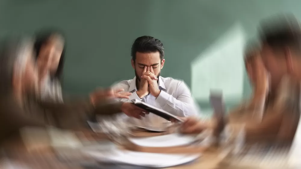 Stress, migraine and motion blur with a business man in a meeting feeling frustrated, tired or overworked. Mental health, anxiety and headache with an exhausted male employee suffering from fatigue / Foto: Jacob Wackerhausen, Getty Images