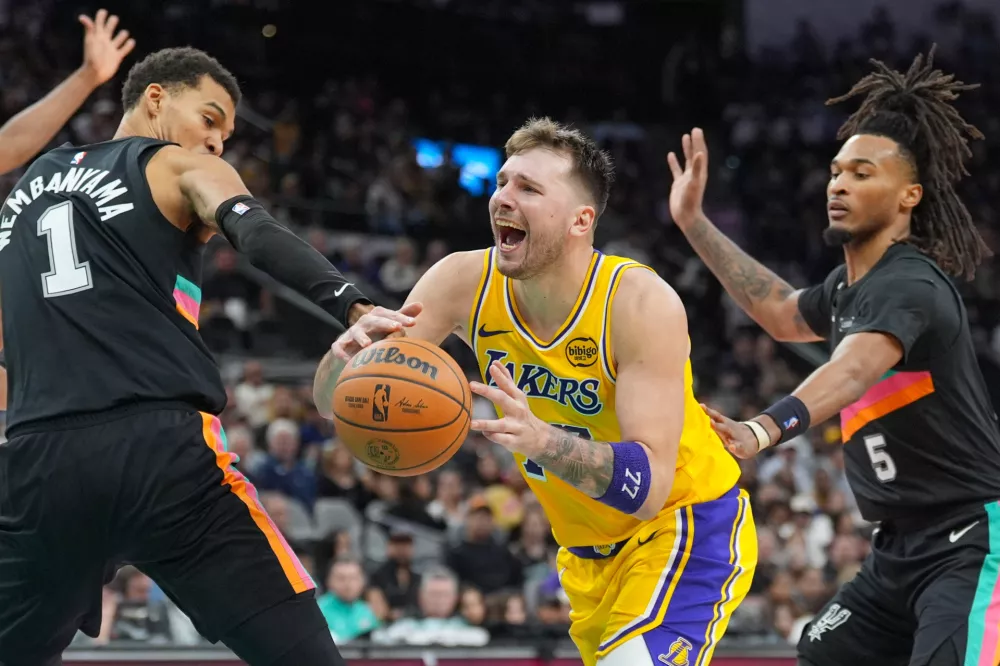Jan 7, 2026; San Antonio, Texas, USA; Los Angeles Lakers forward/guard Luka Dončić (77) draws a foul in between San Antonio Spurs forward/center Victor Wembanyama (1) and guard Stephon Castle (5) in the second half at Frost Bank Center. Mandatory Credit: Daniel Dunn-Imagn Images / Foto: Daniel Dunn