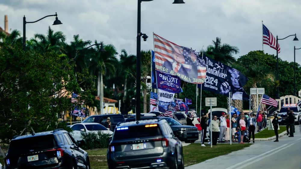 Supporters wave flags as President Donald Trump motorcades to his Mar-a-Lago club through Southern Boulevard, which the Town of Palm Beach Council recently voted to rename "President Donald J. Trump Boulevard," Friday, Jan. 16, 2026, in West Palm Beach, Fla. (AP Photo/Julia Demaree Nikhinson)