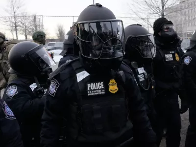 U.S. Customs and Border Protection police officers stand outside the Bishop Henry Whipple Federal Building during a protest on Saturday, Jan. 17, 2026, in Minneapolis. (AP Photo/Yuki Iwamura)