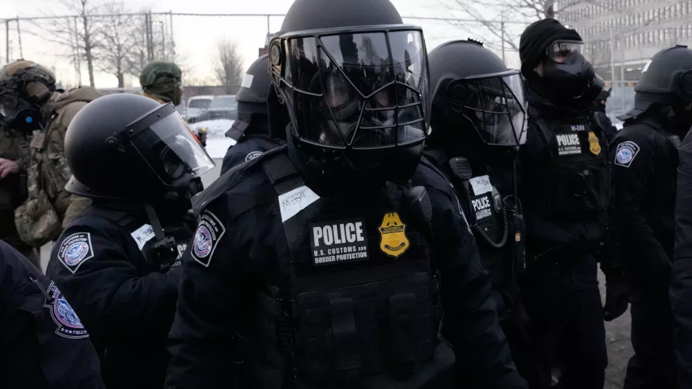 U.S. Customs and Border Protection police officers stand outside the Bishop Henry Whipple Federal Building during a protest on Saturday, Jan. 17, 2026, in Minneapolis. (AP Photo/Yuki Iwamura)