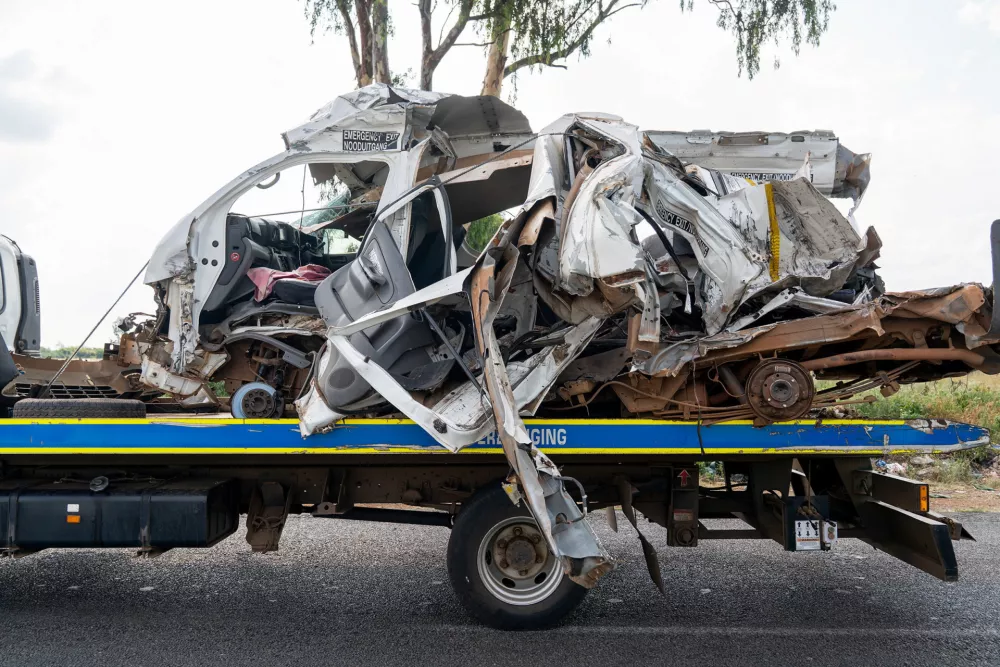The remains of a mini bus taxi on a police tow truck at the scene of a fatal crash of 13 schoolchildren who perished ​when their minibus collided with a truck, in Johannesburg, South Africa, January 19, 2026. REUTERS/Shiraaz Mohamed
