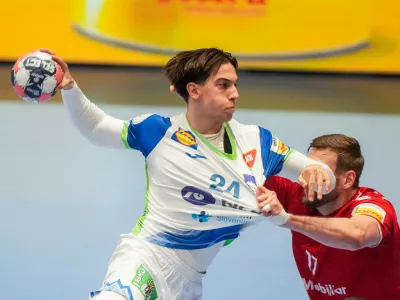 Slovenia's Andraz Makuc, left, and Switzerland's Samuel R&ouml;thlisberger challenge during the European Championship handball match between Switzerland and Slovenia, in Baerum, Norway, Sunday Jan. 18, 2026. (Cornelius Poppe/NTB via AP)