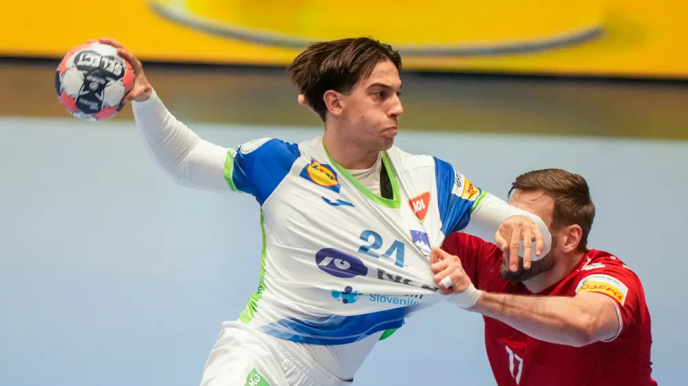 Slovenia's Andraz Makuc, left, and Switzerland's Samuel R&ouml;thlisberger challenge during the European Championship handball match between Switzerland and Slovenia, in Baerum, Norway, Sunday Jan. 18, 2026. (Cornelius Poppe/NTB via AP)
