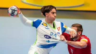 Slovenia's Andraz Makuc, left, and Switzerland's Samuel R&ouml;thlisberger challenge during the European Championship handball match between Switzerland and Slovenia, in Baerum, Norway, Sunday Jan. 18, 2026. (Cornelius Poppe/NTB via AP)