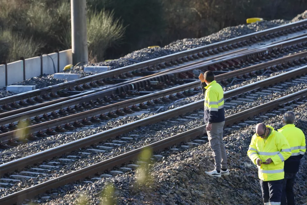 20 January 2026, Spain, Adamuz: People stand on the tracks near the site of a train accident where several dozen were killed on the evening of January 18, 2026, when two high-speed trains traveling in opposite directions derailed near Adamuz in the Andalusian province of C&oacute;rdoba. Photo: Joaquin Corchero/EUROPA PRESS/dpa