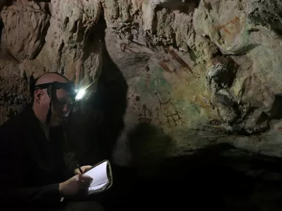 Researcher Maxime Aubert examines an ancient cave painting in a limestone cave called Liang Metanduno on Muna, a small satellite island off the southeastern peninsula of the Indonesian island of Sulawesi, in this photograph released on January 21, 2026. Ahdi Agus Oktaviana/Handout via REUTERS  THIS IMAGE HAS BEEN SUPPLIED BY A THIRD PARTY. NO RESALES. NO ARCHIVES.
