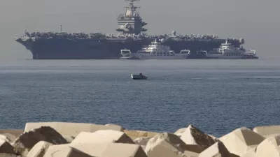 FILE - In this Thursday, March 29, 2012 file photo, a small boat pass in front of the aircraft carrier USS Enterprise is seen anchored of the coast of Faliro, near Athens. The U.S. Navy said Monday, April 9, 2012 that it has deployed a second aircraft carrier to the Persian Gulf region amid rising tensions with Iran over its nuclear program. The deployment of the nuclear-powered USS Enterprise along the Abraham Lincoln carrier strike group marks only the fourth time in the past decade that the Navy has had two aircraft carriers operating at the same time in the Persian Gulf and the Arabian Sea, said Cmdr. Amy Derrick-Frost of the Bahrain-based 5th Fleet. (AP Photo/Petros Giannakouris, File)