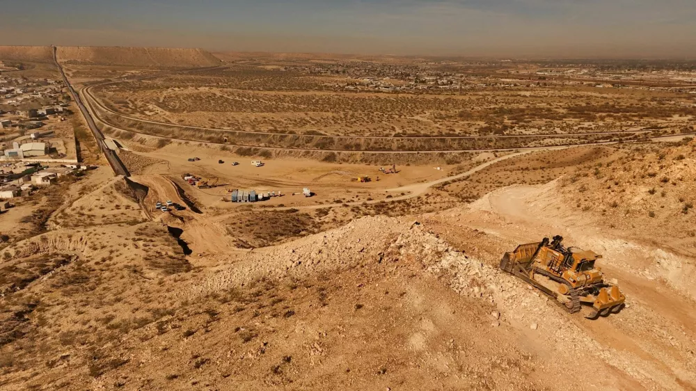 An aerial view shows machinery during the construction of a new section of the border wall at Monte Cristo Rey in Sunland Park, New Mexico, on the U.S.-Mexico border, part of the "Smart Wall" project promoted by U.S. President Donald Trump's administration to combat irregular migration from Mexico into the United States, seen from Ciudad Juarez, Mexico, January 21, 2026. REUTERS/Jose Luis Gonzalez