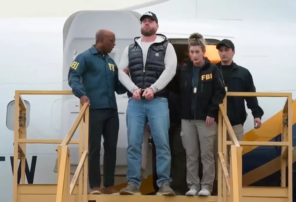 This still photo taken from video and provided by the FBI shows Ryan Wedding a former Canadian Olympic snowboarder facing charges related to drug trafficking and the killing of a federal witness is taken off a plane at Ontario International Airport in Ontario, Calif. on Friday, Jan. 23, 2026. (FBI via AP)
