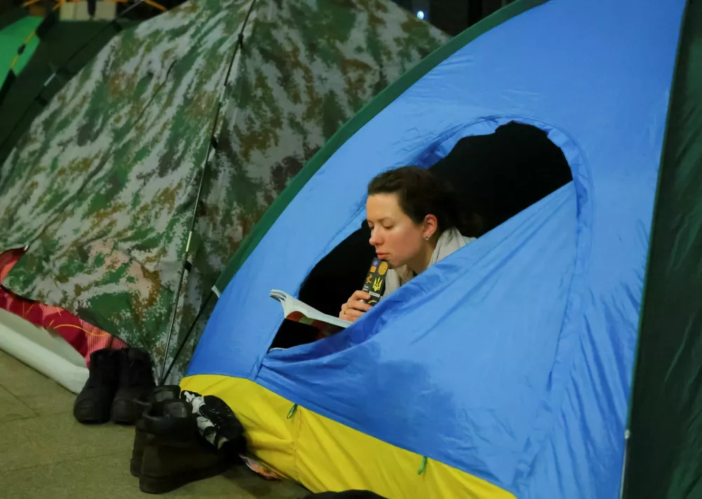 A woman reads a book as she takes shelter inside a metro station during a Russian missile and drone strike, amid Russia's attack on Ukraine, in Kyiv, Ukraine January 24, 2026. REUTERS/Yan Dobronosov
