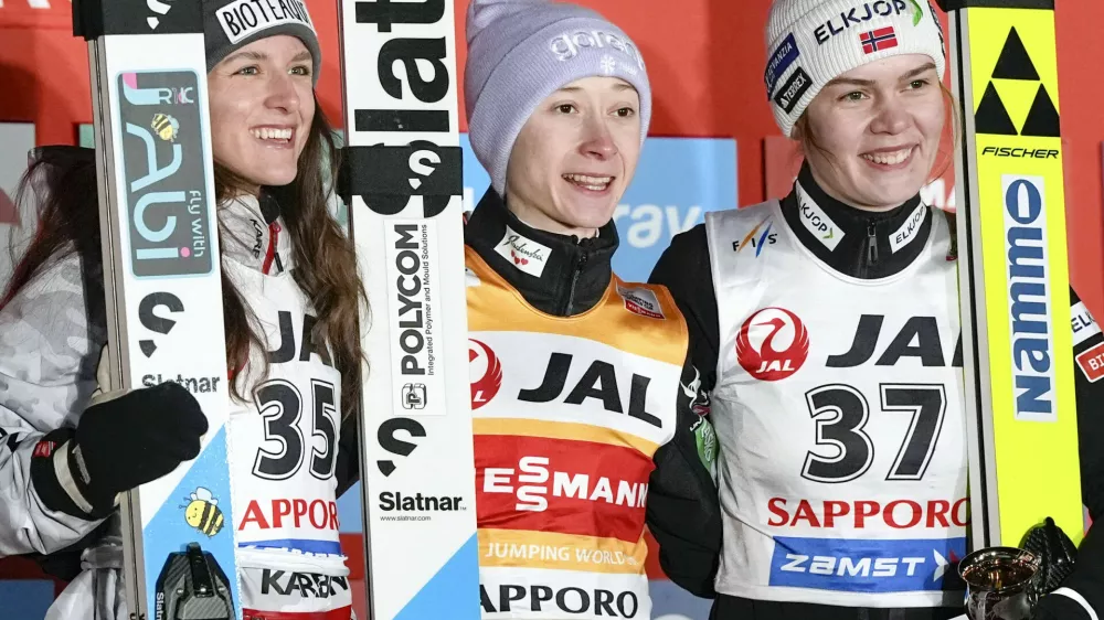 Winner Nika Prevc of Slovenia, center, second place Abigail Strate of Canada, left, and third place Anna Odine Strom of Norway celebrate after the women's large hill individual event, during the Ski Jumping World Cup in Sapporo, northern Japan, Saturday Jan. 24, 2026. (Yuta Omori/Kyodo News via AP)