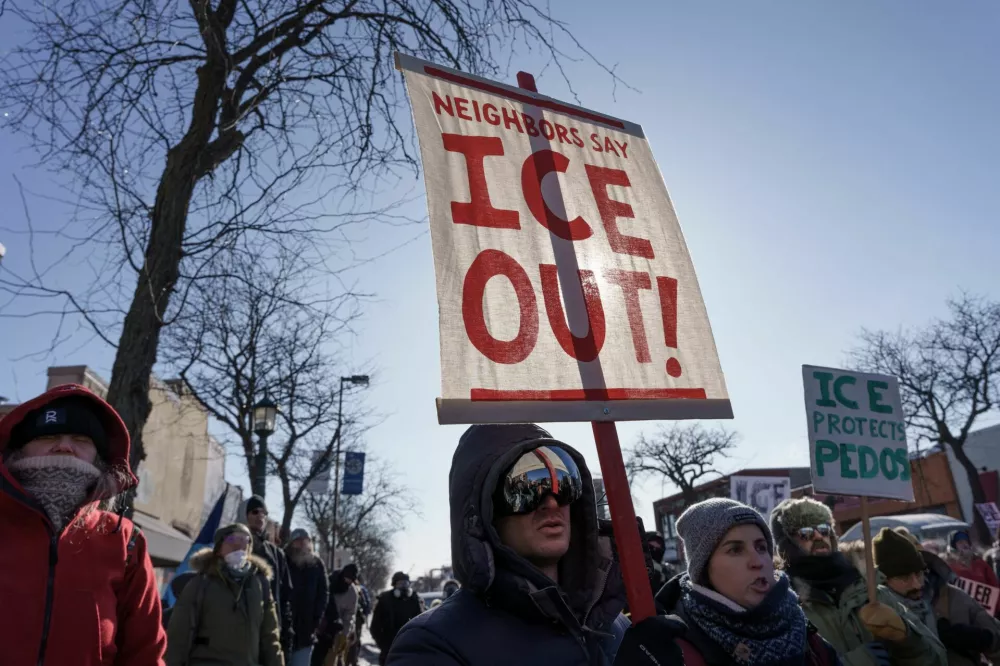 Demonstrators carry signs condemning Immigration and Customs Enforcement (ICE) near the site where a man identified as Alex Pretti was fatally shot by federal agents trying to detain him, in Minneapolis, Minnesota, U.S., January 24, 2026. REUTERS/Tim Evans