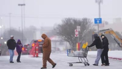 Shoppers brave cold weather as they walk in the parking lot of a store during a winter storm Saturday, Jan. 24, 2026, in Arlington, Texas. (AP Photo/Julio Cortez)