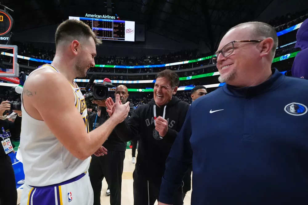Los Angeles Lakers guard Luka Doncic, left, talks with Mark Cuban, center, following an NBA basketball game against the Dallas Mavericks Saturday, Jan. 24, 2026, in Dallas. (AP Photo/Julio Cortez)