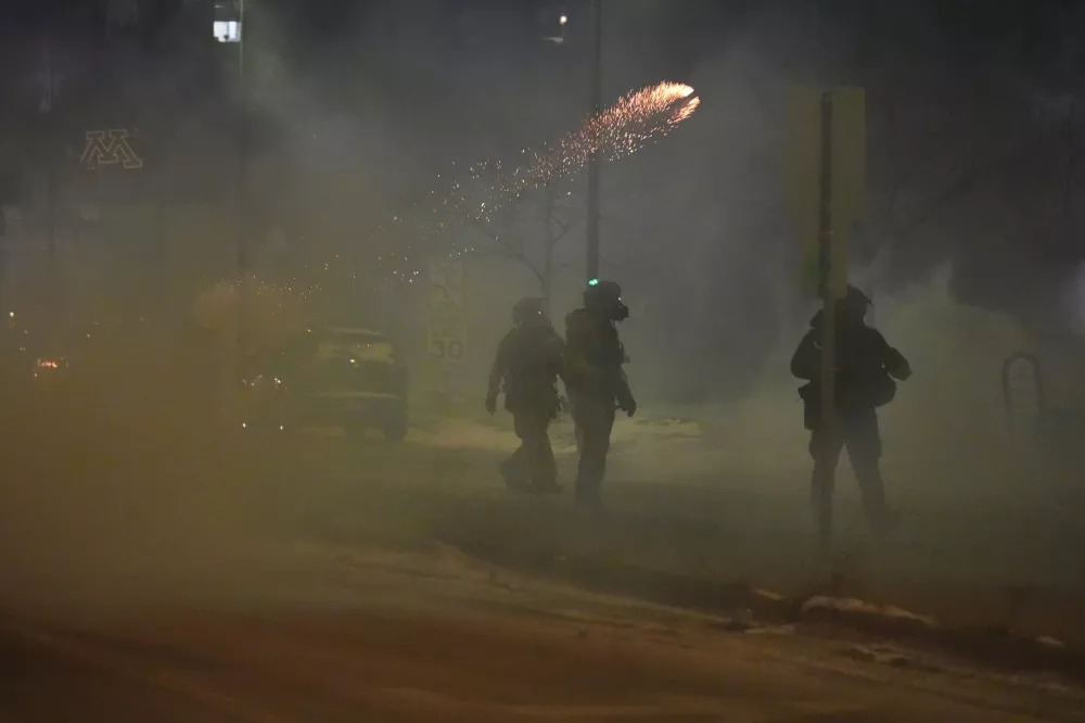Flares are seen as federal agents try to clear the demonstrators near a hotel, using tear gas during a noise demonstration protest in response to federal immigration enforcement operations in the city Sunday, Jan. 25, 2026, in Minneapolis. (AP Photo/Adam Gray)