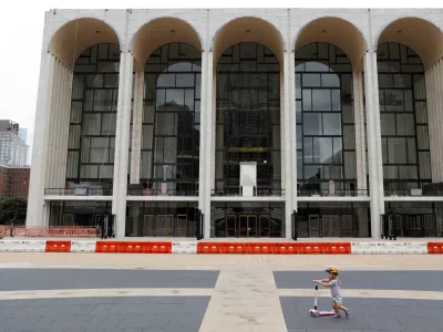 A child plays in front of the Metropolitan Opera House, which announced it will cancel its entire 2020-21 season due to the outbreak of the coronavirus disease (COVID-19) in Manhattan, New York City, U.S., September 26, 2020. REUTERS/Andrew Kelly