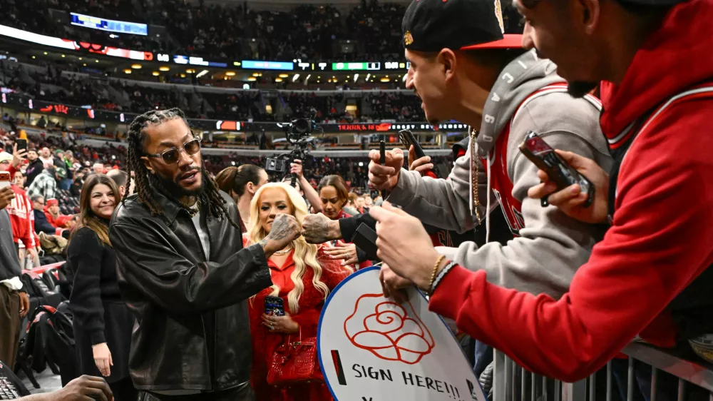 Former Chicago Bulls player Derrick Rose, left, fist bumps fans before an NBA basketball game against the Boston Celtics, Saturday, Jan. 24, 2026, in Chicago. Rose's jersey will be retired after the game today. (AP Photo/Matt Marton)