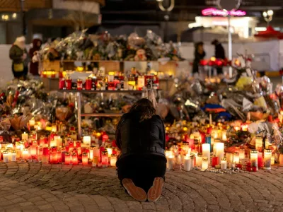 FILE PHOTO: A woman lights a candle at a makeshift memorial outside the "Le Constellation" bar, after a deadly fire and explosion during a New Year's Eve party, in the upscale ski resort of Crans-Montana in southwestern Switzerland, January 5, 2026. REUTERS/Umit Bektas/File Photo