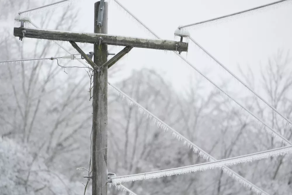 Ice covers lines on a utility pole during a winter storm Sunday, Jan. 25, 2026, in Nashville, Tenn. (AP Photo/George Walker IV)