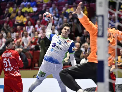 Slovenia's Domen Makuc scores past Croatia's goalkeeper Dominik Kuzmanovic during the men's handball match between Slovenia and Croatia in Malmo, Sweden, Tuesday Jan. 27, 2026. (Johan Nilsson /TT via AP)